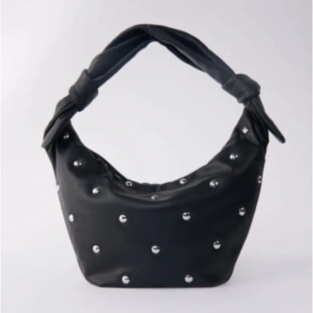 Maje “le bow bag” in black leather with silver studs